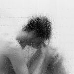 grayscale photo of woman in shower room