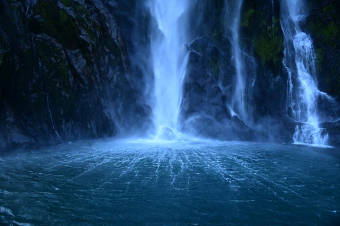 a large waterfall in the middle of a body of water